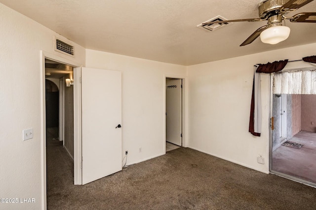 unfurnished bedroom featuring visible vents, carpet floors, and ceiling fan