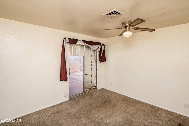 carpeted spare room with a ceiling fan, baseboards, visible vents, and a textured ceiling