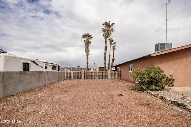 view of yard with central AC unit and fence