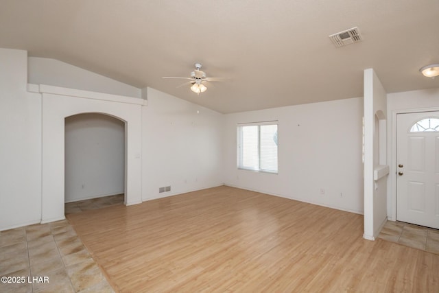 entryway with lofted ceiling, a ceiling fan, visible vents, and light wood-style flooring