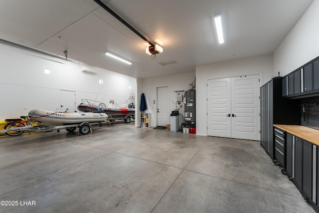 garage with water heater and a garage door opener