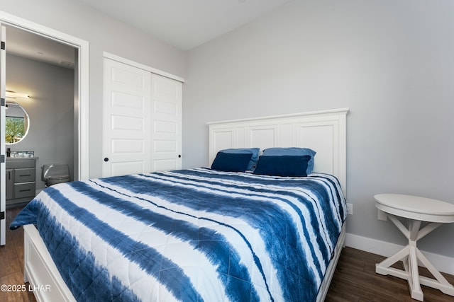 bedroom featuring dark wood-style floors, baseboards, and a closet