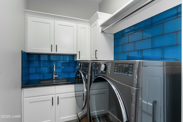 laundry area featuring cabinet space, washer and dryer, and a sink