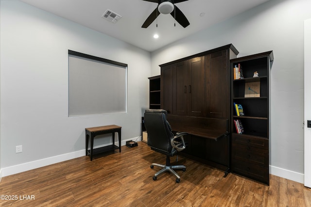 office space featuring visible vents, baseboards, dark wood-type flooring, and a ceiling fan