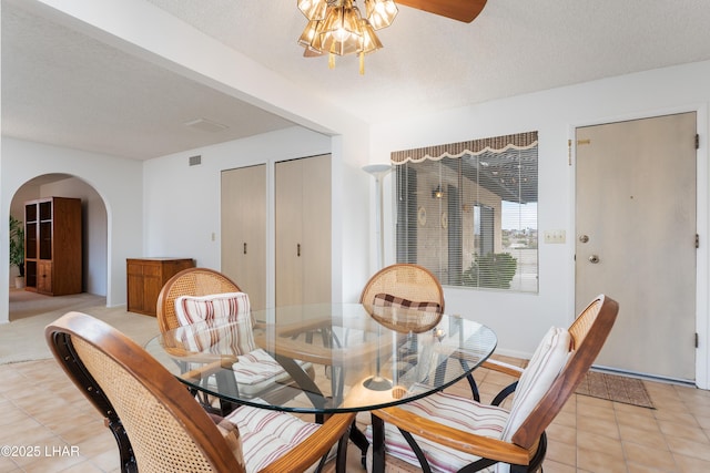 tiled dining room featuring ceiling fan and a textured ceiling