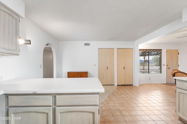 kitchen featuring a textured ceiling and cream cabinetry