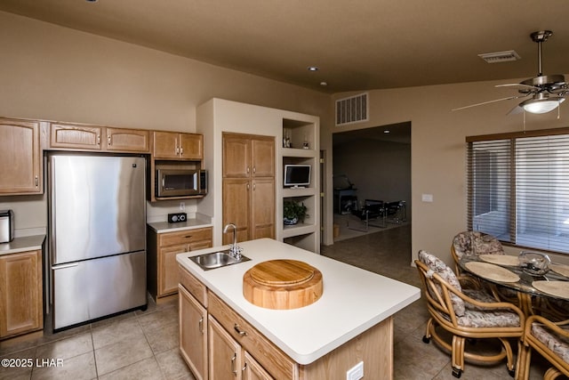 kitchen with light countertops, appliances with stainless steel finishes, a sink, and visible vents