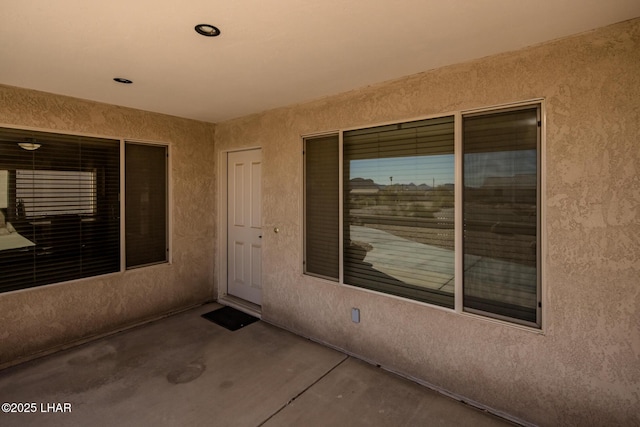 view of exterior entry featuring stucco siding