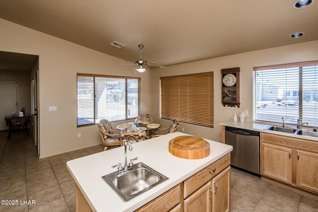 kitchen with a sink, stainless steel dishwasher, and light brown cabinetry