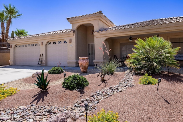 2554 Beverly Glen Dr, Lake Havasu City, AZ 86403 - view of front of home with an attached garage, concrete driveway, stucco siding, a tiled roof, and a ceiling fan