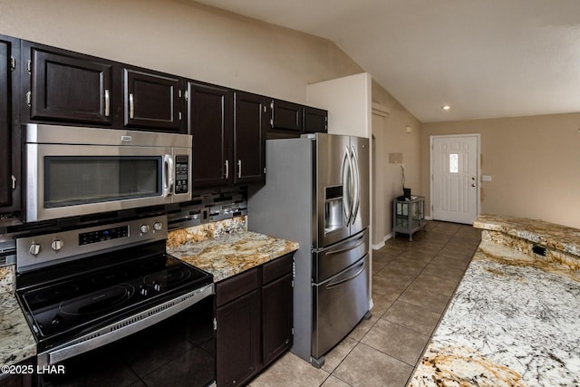 kitchen featuring light tile patterned floors, tasteful backsplash, lofted ceiling, stainless steel appliances, and dark cabinetry