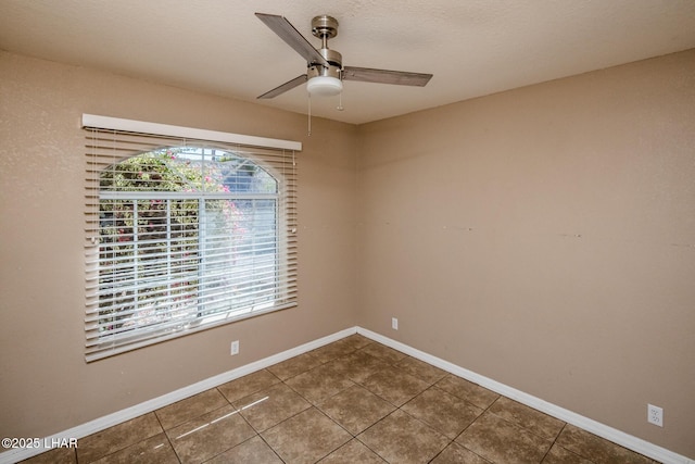 spare room with ceiling fan, baseboards, and tile patterned floors