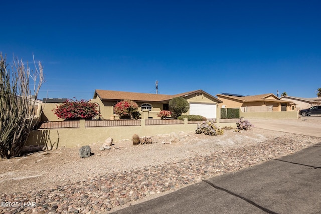 ranch-style home featuring a fenced front yard, an attached garage, and stucco siding