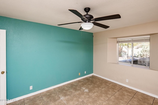 tiled spare room featuring a textured ceiling, a ceiling fan, and baseboards