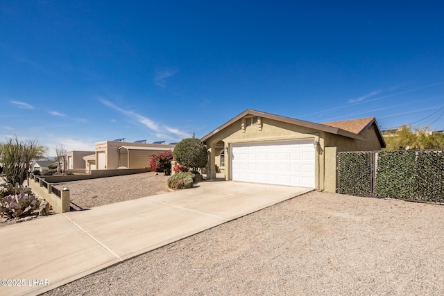 single story home featuring driveway, an attached garage, fence, and stucco siding