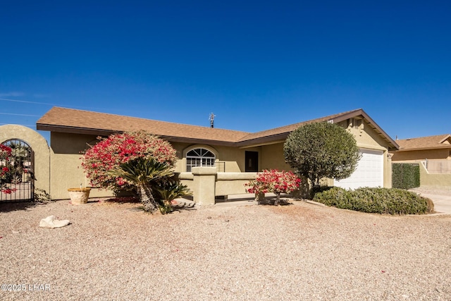 single story home featuring a garage, a gate, and stucco siding