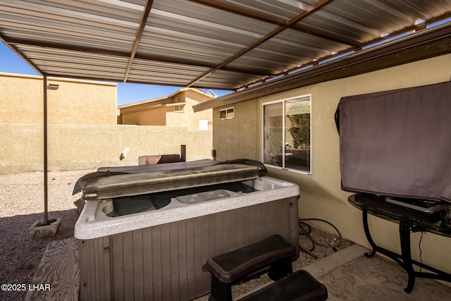 view of patio / terrace featuring fence and a hot tub