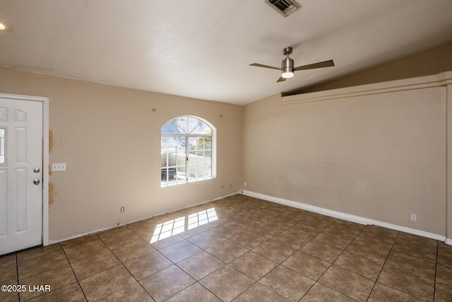 spare room featuring ceiling fan, visible vents, baseboards, vaulted ceiling, and tile patterned floors