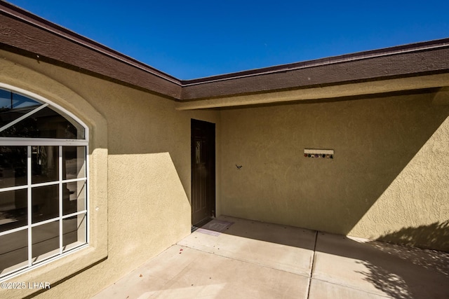 property entrance featuring a patio area and stucco siding