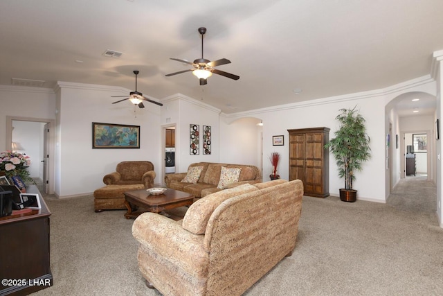 carpeted living room with ceiling fan, ornamental molding, and washer / dryer