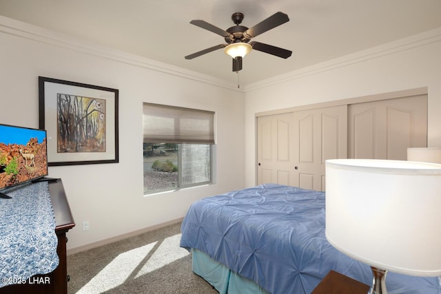 bedroom featuring ceiling fan, carpet floors, crown molding, and a closet