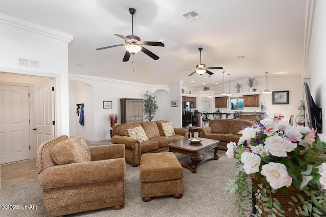 living room with vaulted ceiling, ceiling fan, and ornamental molding