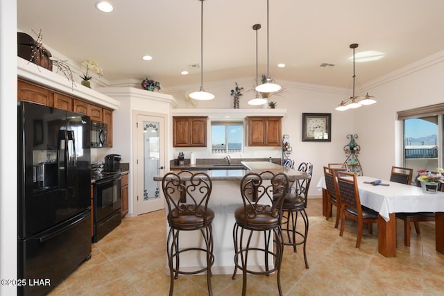 kitchen with sink, a kitchen island, black appliances, and hanging light fixtures