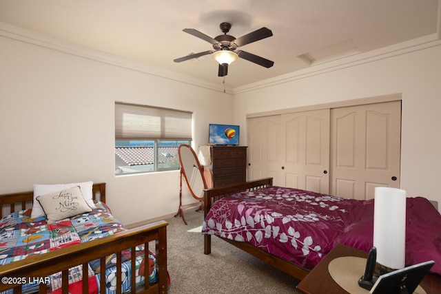 carpeted bedroom with ceiling fan, a closet, and crown molding