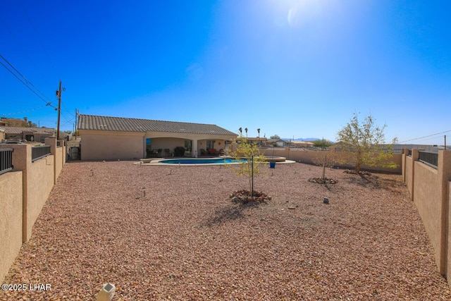 back of property with a patio and a fenced in pool