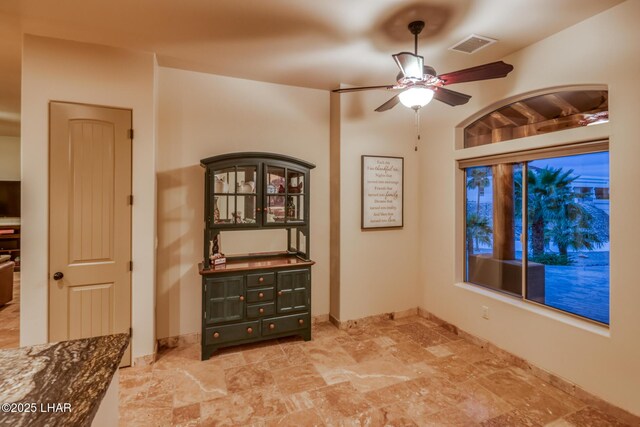 unfurnished room featuring baseboards, visible vents, and a ceiling fan