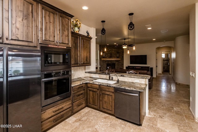 kitchen featuring arched walkways, freestanding refrigerator, stainless steel oven, black microwave, and dishwasher