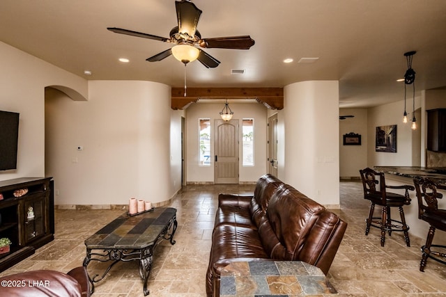 living room featuring arched walkways, recessed lighting, stone tile flooring, visible vents, and baseboards