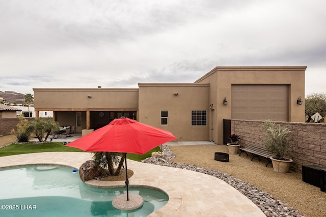 back of property featuring a patio area, fence, an outdoor pool, and stucco siding