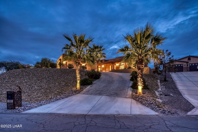 view of front of home featuring decorative driveway, a tile roof, and stucco siding