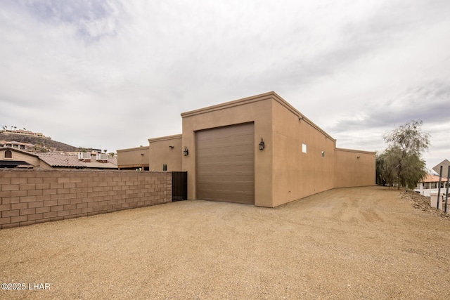 exterior space featuring an outbuilding, driveway, and fence