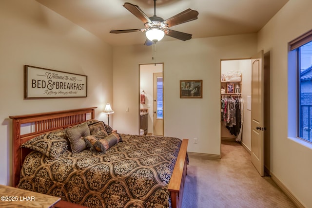 bedroom featuring a ceiling fan, light carpet, connected bathroom, and baseboards