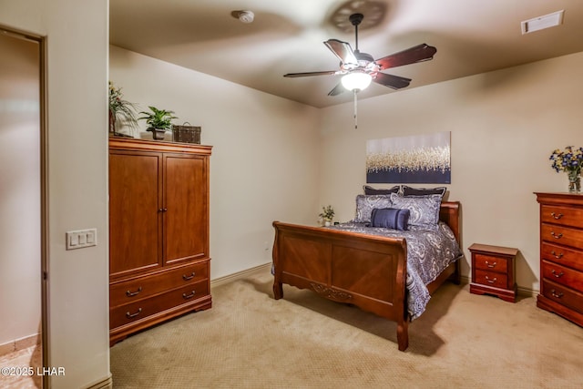 bedroom featuring visible vents, a ceiling fan, and light colored carpet