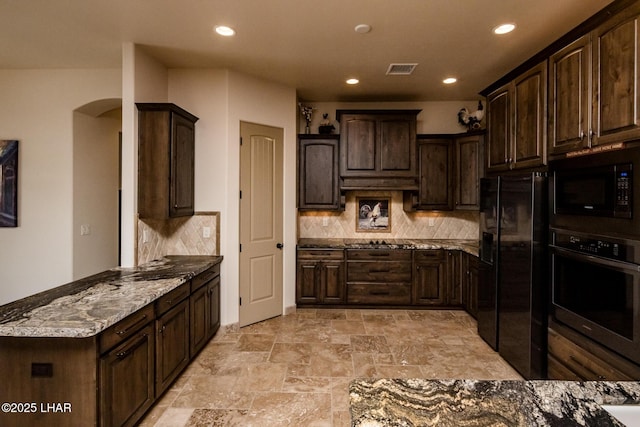 kitchen with arched walkways, black fridge with ice dispenser, stainless steel oven, dark brown cabinets, and built in microwave