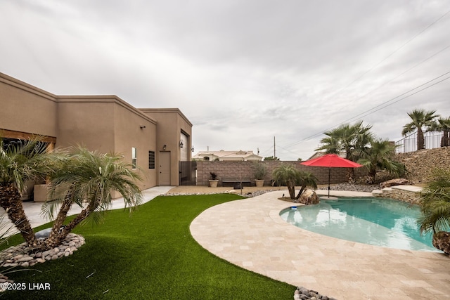 view of swimming pool with a patio area, a fenced in pool, fence, and a lawn