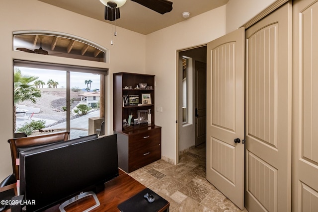 office area with ceiling fan and stone finish flooring