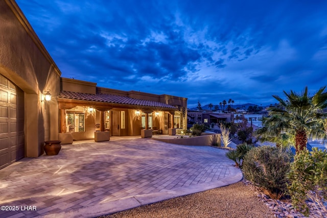 exterior space with a tiled roof and stucco siding