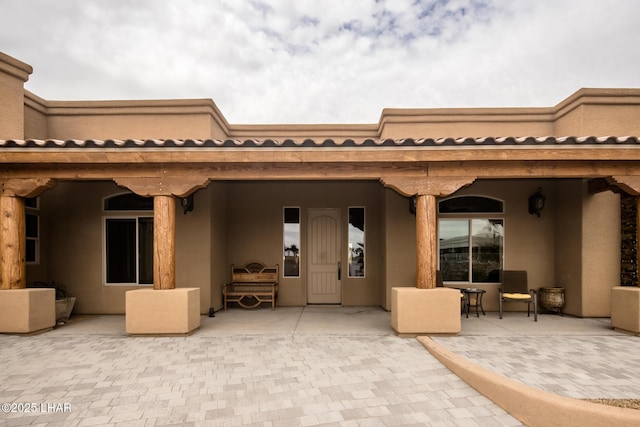 rear view of property featuring a patio and stucco siding