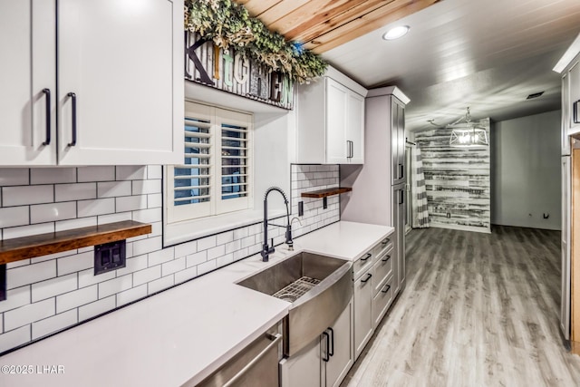 kitchen with sink, wood ceiling, hanging light fixtures, tasteful backsplash, and light hardwood / wood-style floors