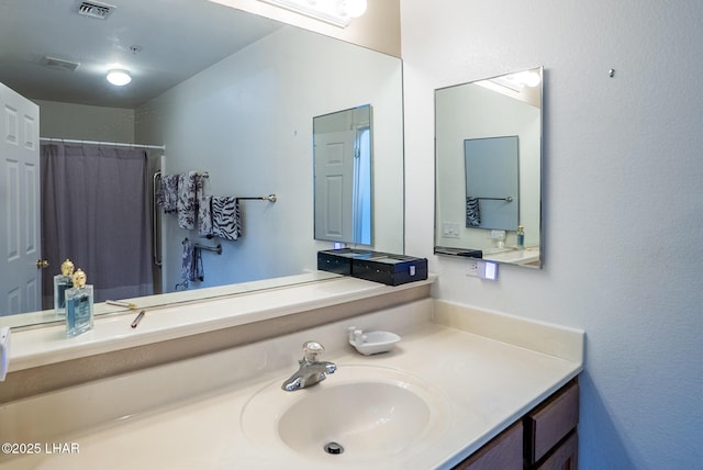 bathroom featuring visible vents, curtained shower, and vanity