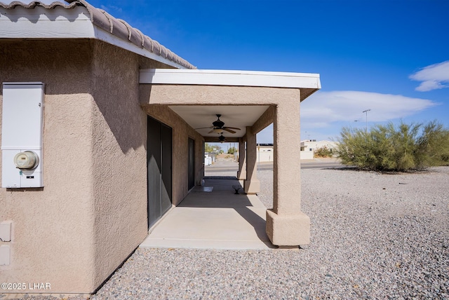 exterior space featuring stucco siding, a patio, a ceiling fan, and a tiled roof