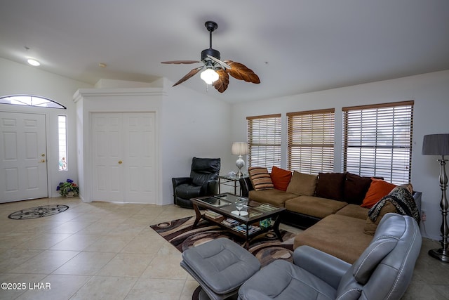 living area with vaulted ceiling, light tile patterned floors, a wealth of natural light, and ceiling fan