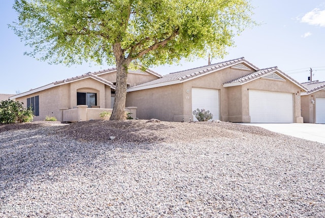 ranch-style house with concrete driveway, a garage, and stucco siding