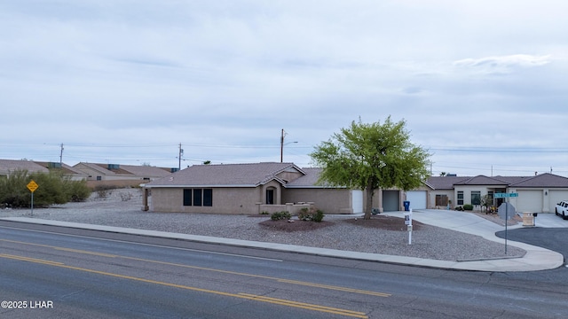 2460 Hummingbird Ln Unit 101, Lake Havasu City, AZ 86403 - view of front facade featuring a tile roof, a garage, driveway, and stucco siding