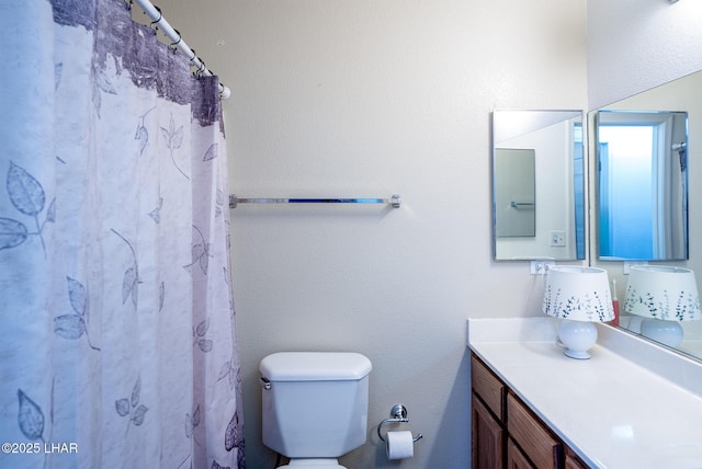 full bathroom featuring curtained shower, toilet, and vanity