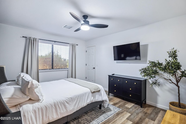 bedroom featuring wood finished floors, visible vents, baseboards, and ceiling fan